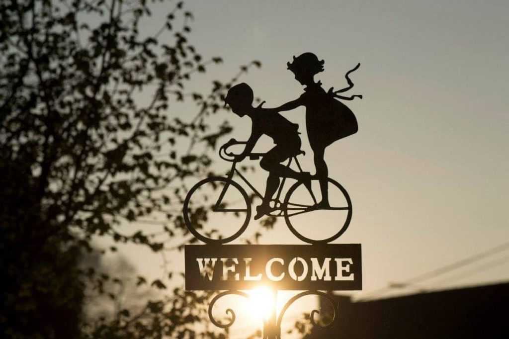 Welcome sign with children riding a bike